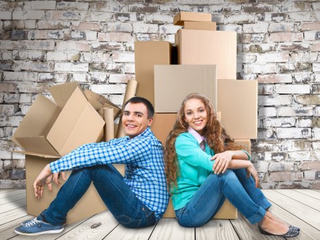 Professional movers carrying furniture through a narrow staircase in Islington
